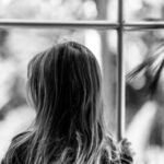 窓の外を見つめる子